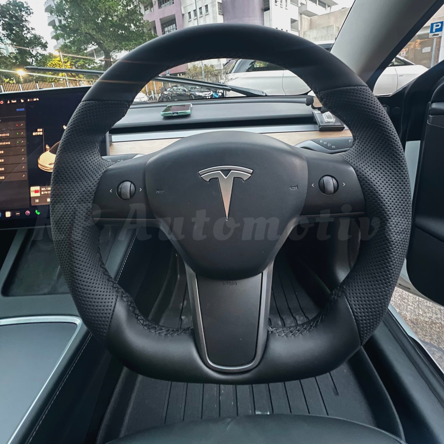 Black perforated leather steering wheel with Tesla logo and buttons