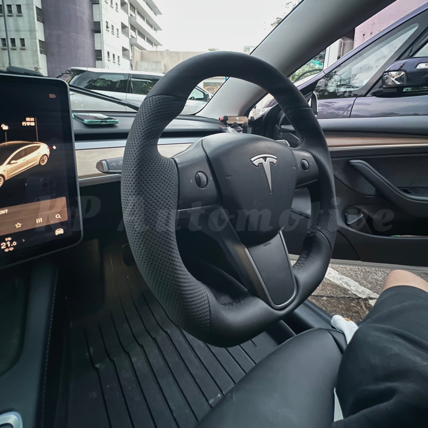 Black perforated leather steering wheel, Tesla logo center, spoke grips